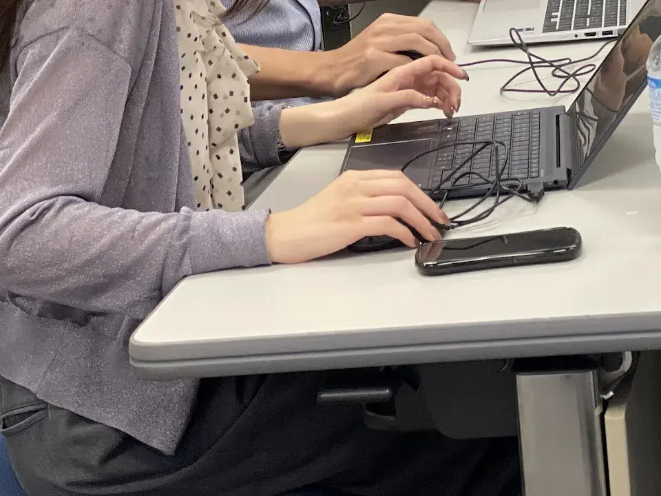 Hands drawing a business diagram on a laptop