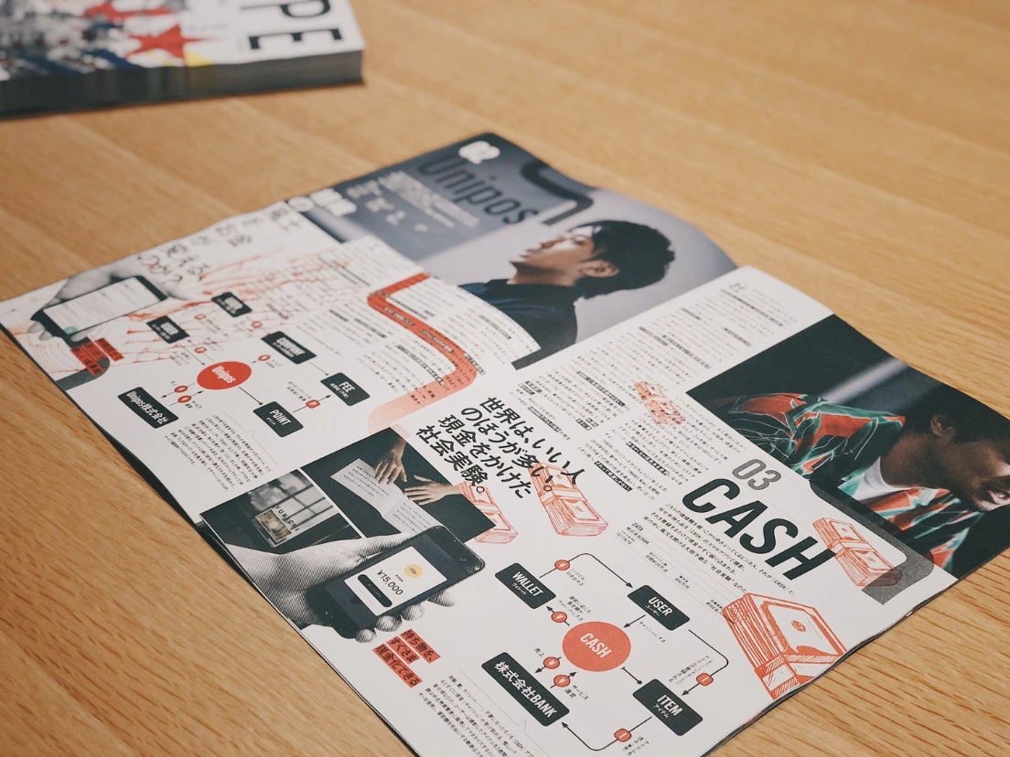 見開きの誌面。左ページに Unipos、右ページに CASH のビジネスモデル図解が、赤い線の図として載っている。